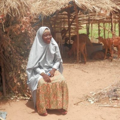 Out of the Margins #3 – Strength in the ashes Hasana sits proudly in front of the hut she built for herself, amidst the ashes of her old home.